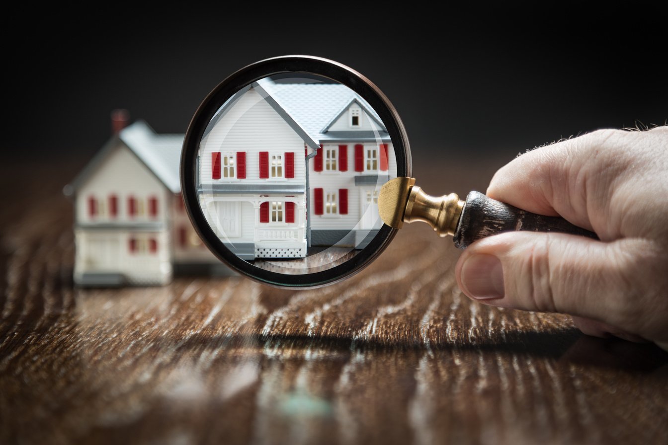 Hand Holding Magnifying Glass  on Scale Model